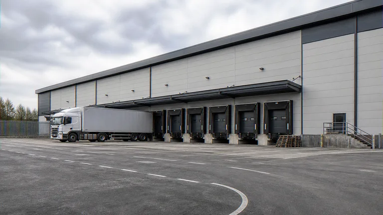 Commercial CGI of a logistics warehouse looking from the yard toward the docks